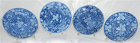 Quattro piatti in porcellana su fondo blu con decorazione floreale (difetti)...