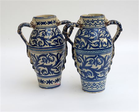 Coppia di vasi biansati in maiolica con decorazione a girali fogliati e fasce...