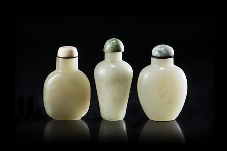 Tre snuff bottles in giada color celadon, di varie forme, con coperchio in...