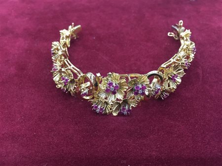 BRACCIALE IN ORO, RUBINI E DIAMANTI, ANNI '50 decorato a motivi fogliacei,...