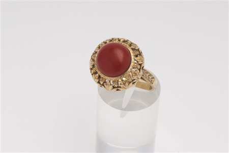 ANELLO IN ORO E CORALLO decorato con corallo cabochon, cornice in oro a...