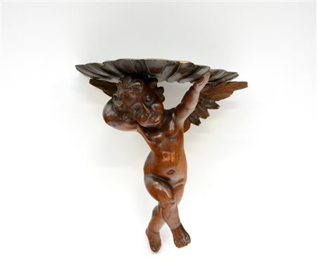 Mensola in legno a forma di putto che sorregge un pianetto sagomato (h.cm 36)...