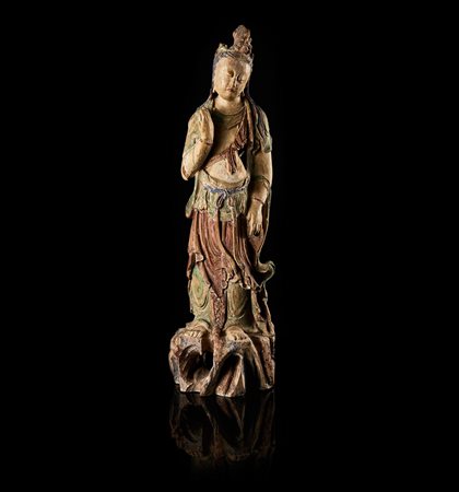 Scultura in legno policromo raffigurante una Guanyin stante su rocce, il capo...