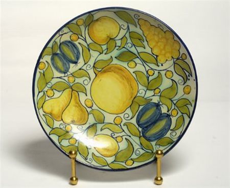 Piatto in ceramica, con decori a frutti sul cavetto e bordo blu.