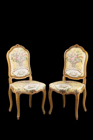Due sedie in legno intagliato, laccato e dorato con cimasa dipinta a foglie e...