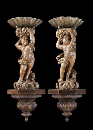 Arte del sec. XVII. Coppia di sculture in legno dorato raffiguranti putti che...