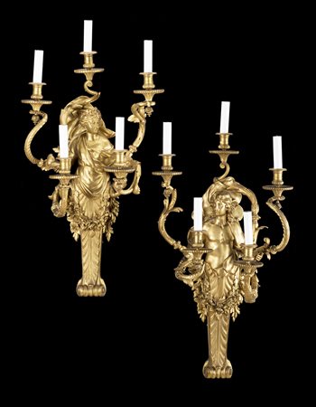 Coppia di appliques a cinque fiamme in bronzo dorato decorate a erme che...