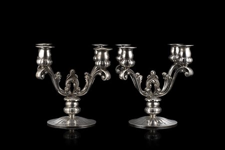 Coppia di candelabri in argento a quattro fiamme con base circolare fesonata,...