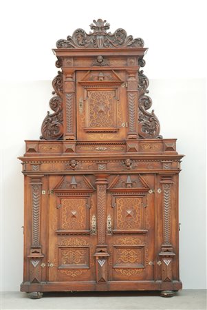 Credenza con alzata di struttura architettonica decorata a teste di putti...