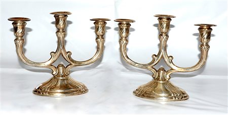 Coppia di candelabri in argento a tre fiamme con base di forma ovale, bracci...