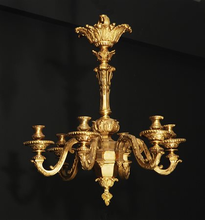 Lampadario in bronzo dorato a sei bracci ricurvi decorato in rilievo a motivi...