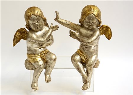 Coppia di antiche sculture raffiguranti dei putti alati in legno dorato e...