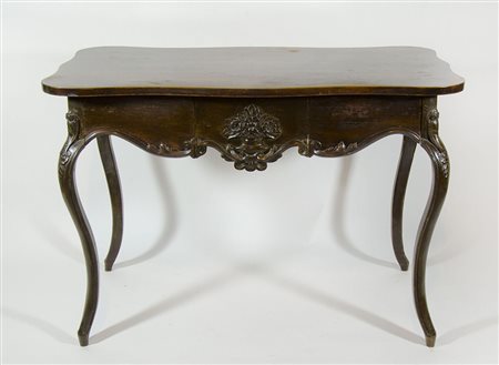 Tavolo-scrivania in legno com piano sagomato su alte gambe a sciabola. cm....