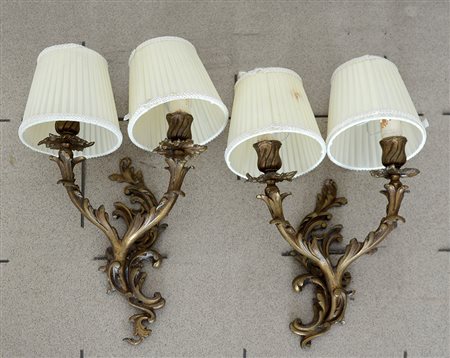 Coppia di appliques a due luci in bronzo dorato decorato a volute (h cm 35)...