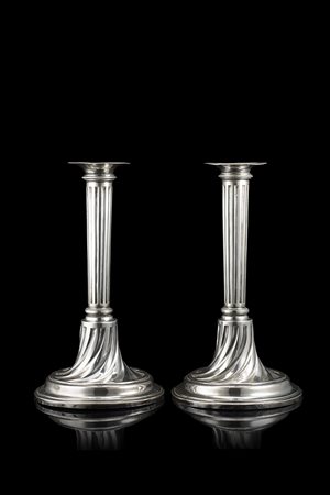 Coppia di candelieri in argento con piede circolare e fusto a colonna,...