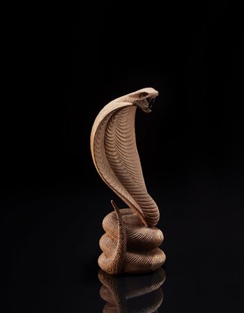 Manifattura orientale. Scultura lignea raffigurante un cobra (h. cm 28)...