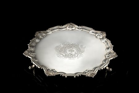 Salver in argento con fondo liscio e stemma inciso; bordo mistilineo a volute...