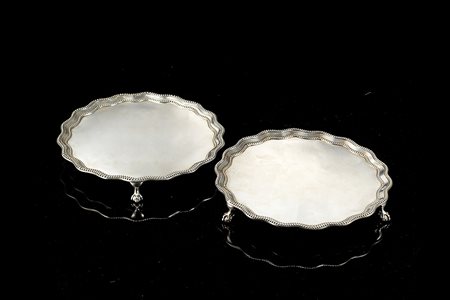 Coppia di salver in argento di forma circolare sagomata con fondo liscio,...