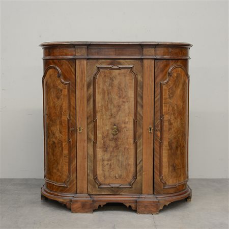 Credenza a fronte curvo lastronata in noce, tre ante riquadrate da sagome e...