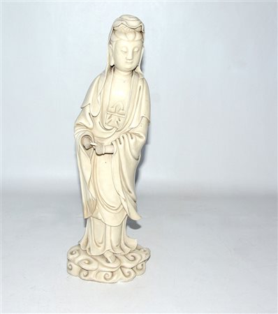 Scultura raffigurante Guanyin in porcellana Blanc-de-Chine color avorio....