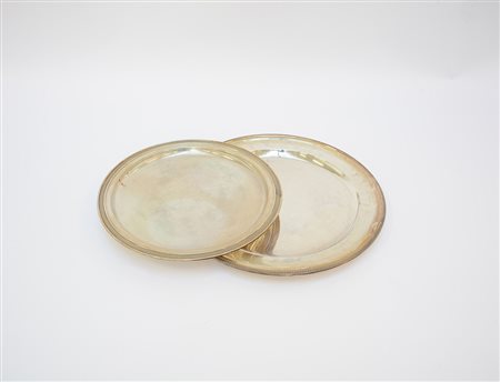 Due piatti in argento di forma circolare con bordura a palmette. Milano, metà...