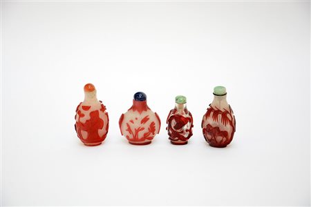 Quattro snuff bottles in vetro con diversi decori e misure, tappini in pietra...