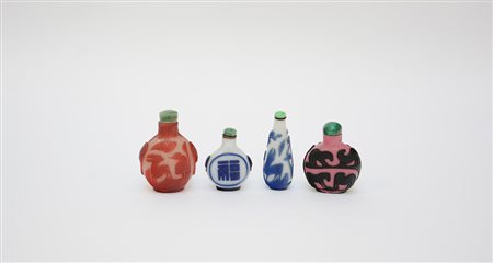 Quattro snuff bottles in vetro con diversi decori e misure, tappini in pietra...