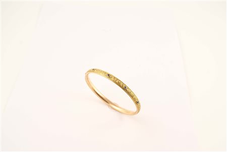 Bracciale a manetta in oro giallo 14kt inciso con incastonati cinque zaffiri...