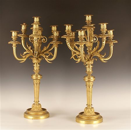 Coppia di candelabri a sette fiamme in bronzo dorato e finemente cesellato a...