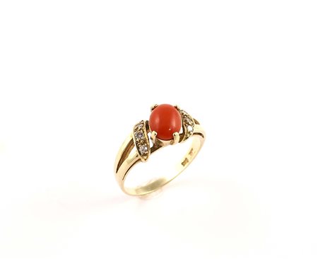 Anello in oro giallo 18kt con al centro corallo rosso di forma ovale e ai...