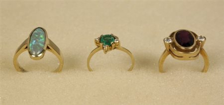 Firmato, datato. Tre anelli in oro giallo di cui uno con opale, uno con...