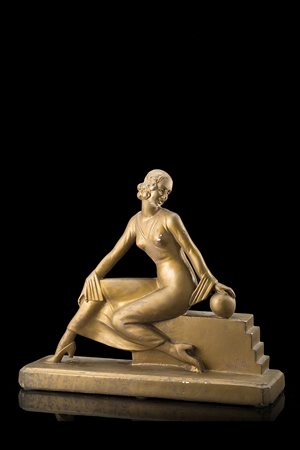 Scultura di gusto déco in terracotta dorata raffigurante una donna seduta....