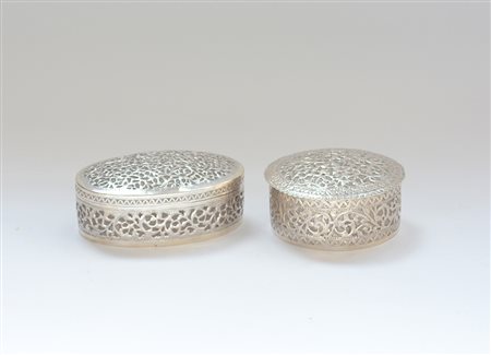 Due scatole in argento rispettivamente di forma ovale e circolare decorati a...