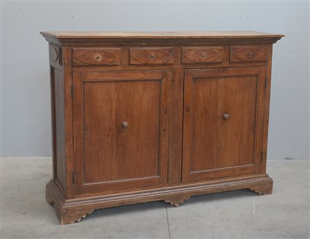 Credenza in noce con due ante riquadrate e quattro cassetti sottopiano...