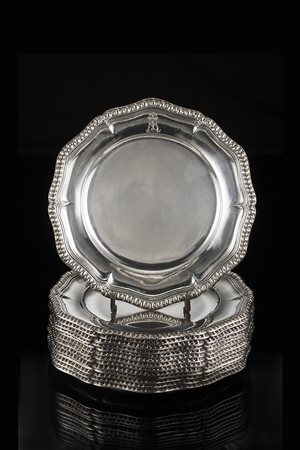 Quattordici piatti in argento di forma circolare sagomata con bordura...