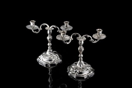 Coppia di doppieri in argento decorati in stile barocchetto a volute mosse,...