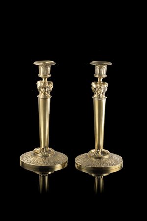 Coppia di candelieri in bronzo con portacandele sorretto da colonna liscia...