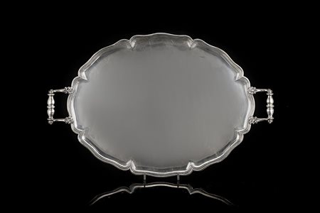 Vassoio in argento di forma ovale sagomata con bordura modanata e manici a...