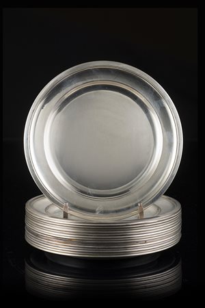 Lotto di sedici piatti in argento di forma circolare con superficie liscia....