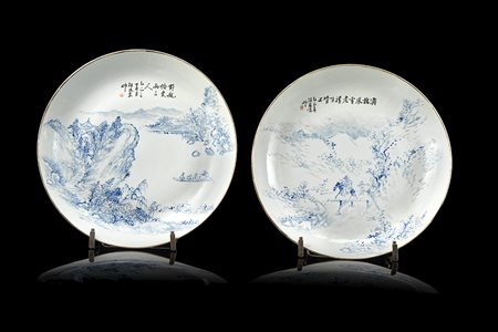 Coppia di piatti in porcellana bianca e blu decorati con scene di paesaggio e...