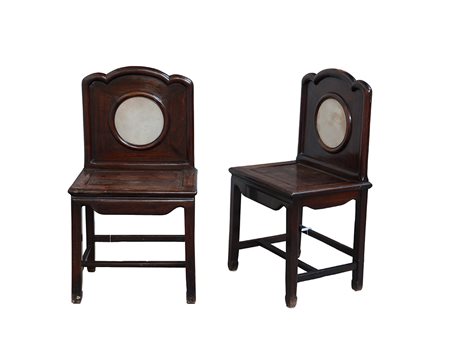 Due sedie in legno dalla seduta quadrata e schienale con placca circolare in...