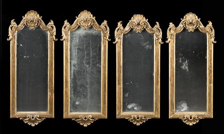 Gruppo di quattro antiche specchiere in legno intagliato e dorato con cimasa...