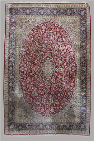 Tappeto Kirman, Persia secolo XX. Disegno a medaglione su fondo rosso,...