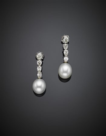 Orecchini pendenti in oro bianco e diamanti a goccia terminati da due perle...