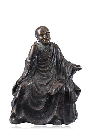 Scultura in bronzo raffigurante monaco in posizione seduta, la testa rasata,...
