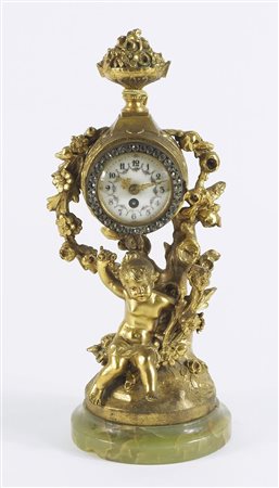 Orologio da tavolo in bronzo dorato con figura di putto al centro, base in...