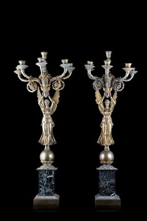 Coppia di candelieri in bronzo dorato con fusto a figura femminile alata poggia