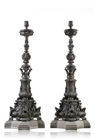 Coppia di importanti torciere in bronzo con fusto decorato a figure alate, anim