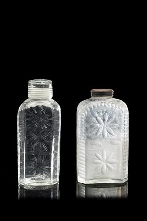 Lotto di due bottiglie in vetro incolore decorate a motivi stilizzati, una con