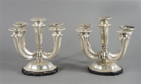 Paio di candelabri in argento a 5 fiamme, su base in legno. H. tot cm. 20.